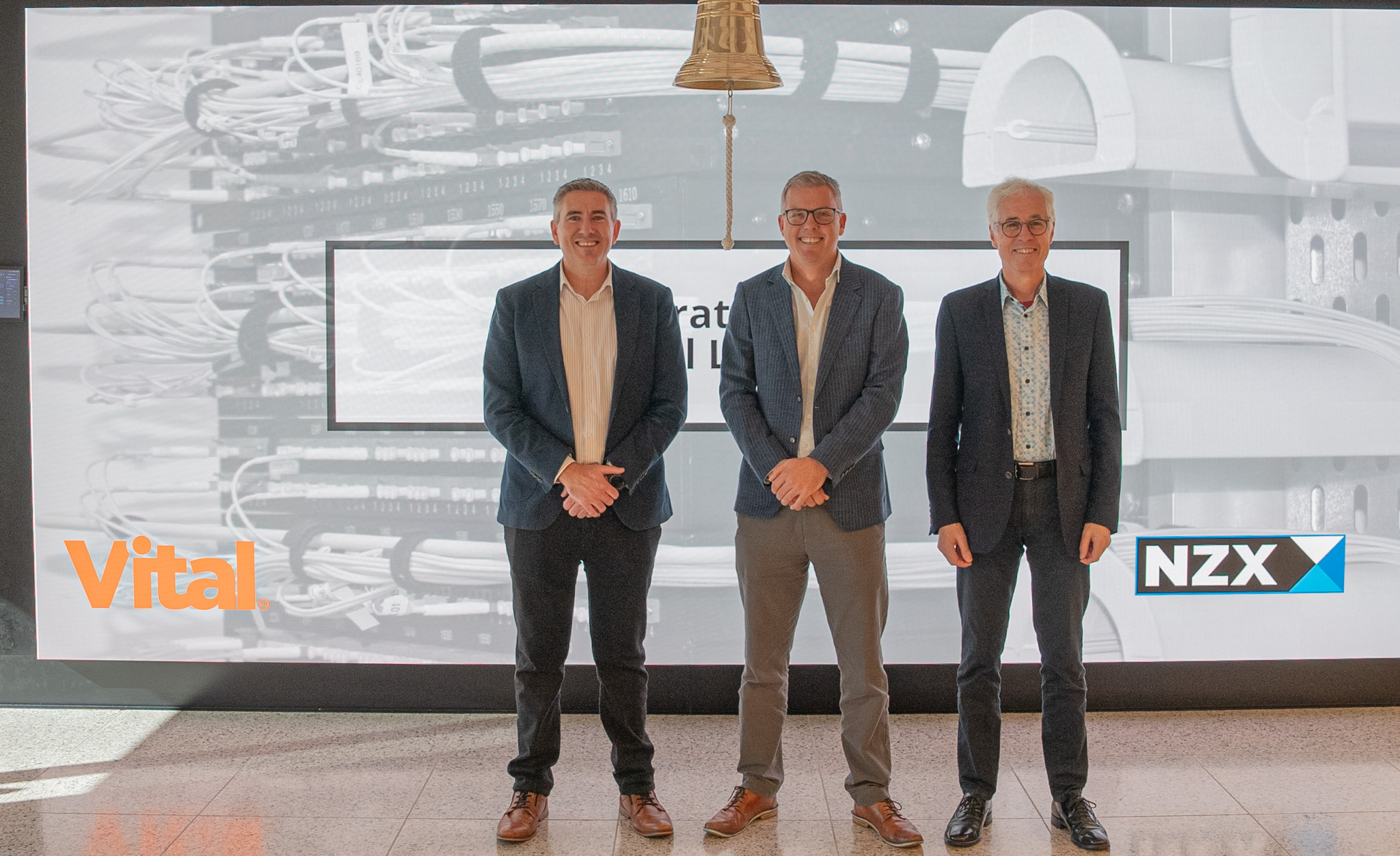 Image of Vital's CEO, CFO and Chair standing next to NZX bell